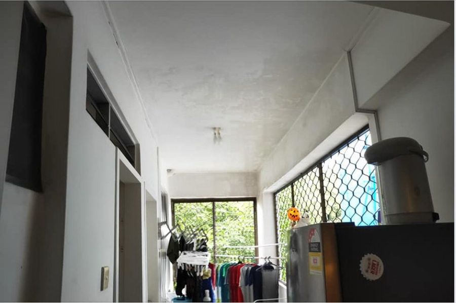 Narrow condo service yard and corridor being inspected for mould